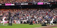 Ein Baseballfeld, zu sehen sind ein Pitcher und ein Batter vor Publikum