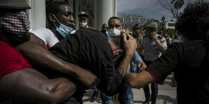 Polizisten in Zivil halten einen regierungskritischen Demonstranten während einer Demonstration fest