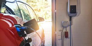 Ein Elektroauto beim Laden an der Wallbox zuhause in der Garage