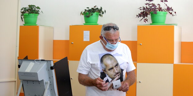 Ein Mann, der ein T-Shirt mit einem Bild des ehemaligen bulgarischen Premierministers Bojko Borissow trägt, geht am 11. Juli in einem Wahllokal in Sofia, Bulgarien, während einer vorgezogenen Parlamentswahl ab.