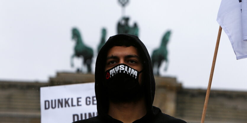 Ein Protestant steht vor dem Brandenburger Tor