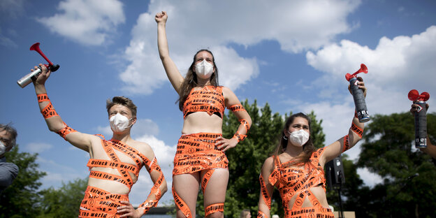 Protest Hitzealarm, 3 junge Menschen haben sich mit Tapeband beklebt