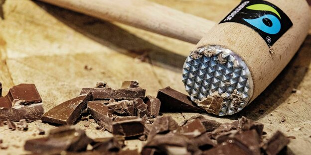 Hammer mit Fairtrade Logo - daneben zerbröckelte Schokolade