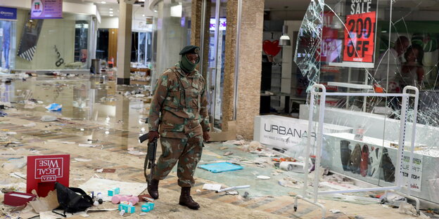 Ein Soldat mit Maschinengewehr läuft durch ein geplündertes Kaufhaus