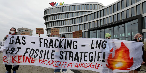 Drei Personen halten ein Transparent gegen Gas und Fracking