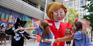 Demonstrierende mit einer Merkel-Puppe