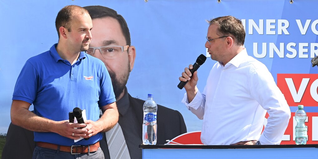 Zwei AfD-Politiker stehen während einer Wahlkampfveranstaltung ihrer Partei auf einer Bühne.