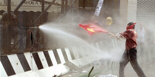 Ein Demonstrant kämpft gegen einen Wasserwerfer an