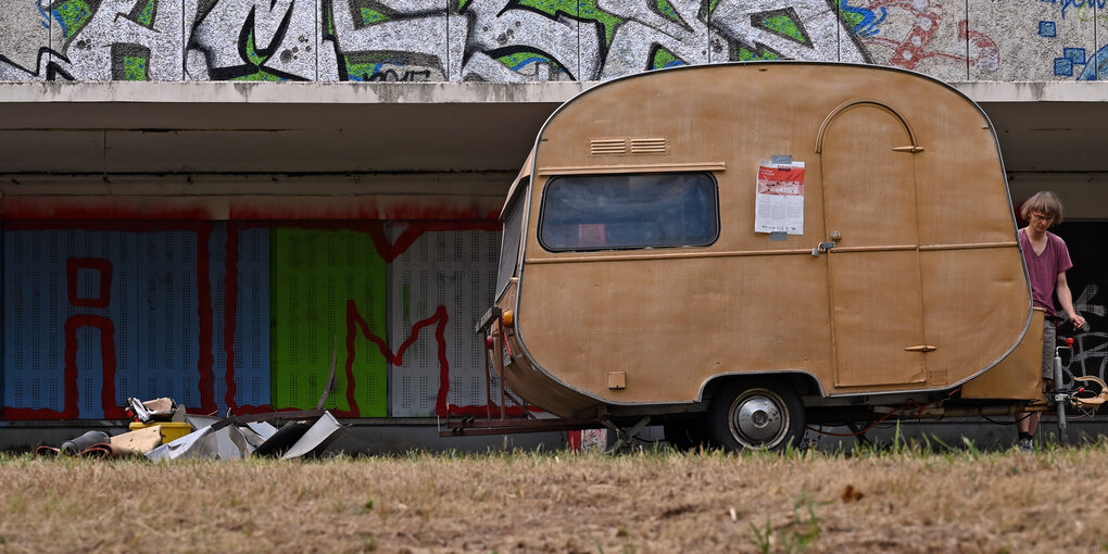 Ein alter Wohnwagen steht vor einer ehemaligen Kaufhalle im Plattenbaugebiet Fritz Heckert in Chemnitz