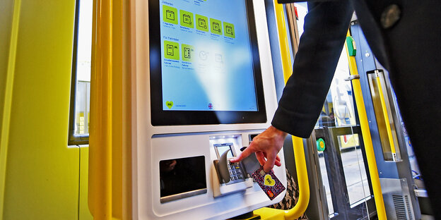 Eine Tram von innen: Ein BVG-Sprecher bezahlt ein Straßenbahn-Ticket mit einer Karte an einem neuen Automaten
