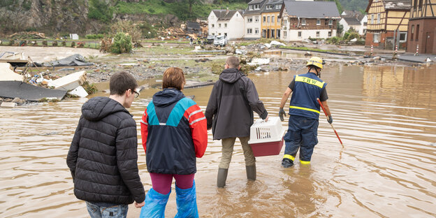 EIne Personengruppe stapft durchs Hochwasser