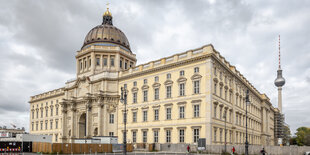 Der Autor Christian Walther sitzt vor dem Humboldt-Forum am Rand eines Springbrunnens