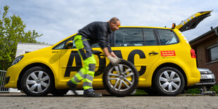 Ein Pannenhelfer vor seinem ADAC Auto mit Reifen