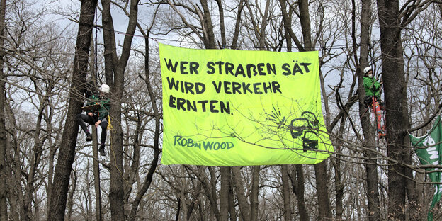 "Wer Straßen sät wird Verkehr ernten" steht auf einem Transparent, das Umwelt-Aktivisten zwischen Bäumen in der Wuhlheide gespannt haben. Mit der Aktion protestieren sie gegen den Bau einer Straßenverbindung, der Tangentialverbindung Ost