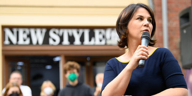 Grünen-Spitzenkandidatin Baerbock im blauen Kleid mit Mikrofon in der Hand