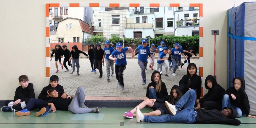 Tänzer:innen in Gruppe vor einem Wandbild