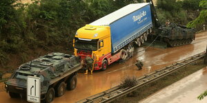 Panzer schleppt LKW aus Schlamm heraus