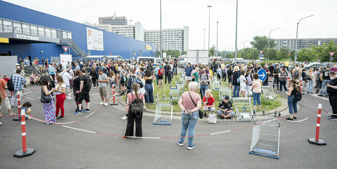 Viele Menschen stehen vor einem Möbelmarkt