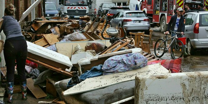 Möbel stehen auf einer Straße zwischen Schlamm und Autos