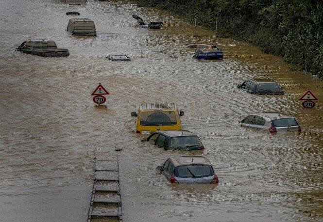 Zahlreiche Autos stehen bis zum Dach in schlammigem Wasser.