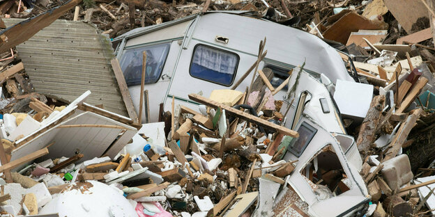 Ein zerstörter Wohnwagen umgeben von Schutt