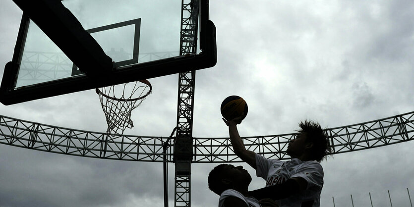 Zwei basketballspieler unter dem Korb.