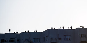 Musiker stehen auf dem Dach eines Hochhauses und spielen ihre Instrumente