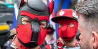 Männer mit Hunde-Masken nehmen an der Christopher-Street-Day-Parade in der Münchner Innenstadt teil.