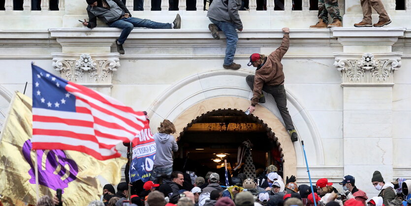 Eine Menschenmenge mit US-Flaggen und aufsteigendem Rauch