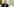 der 96-Jährige Archie Whie steht vor Gemälden und bickt in die Kamera