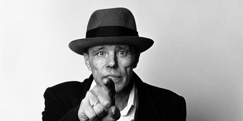 Joseph Beuys zeigt mit dem Finger Richtung Kamera.