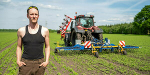 Ein Bauer mit Traktor auf einem Feld.