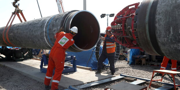 Zwei Arbeiter bauen an der Pipeline Nord Stream 2