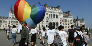 Junge Menschen marschieren, einer trägt einen Luft in Regenbogenfarben und in Herzform