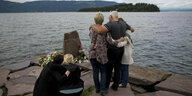 Menschen stehen am Ufer, um dem Attentat von Utøya zu gedenken.