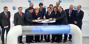 Gerhard Schröder une eine Gruppe internationaler Politiker (darunter Merkel, Öettinger und der französische Premierminister Francois Fillon) drehen an einem symbolischen Gasrad