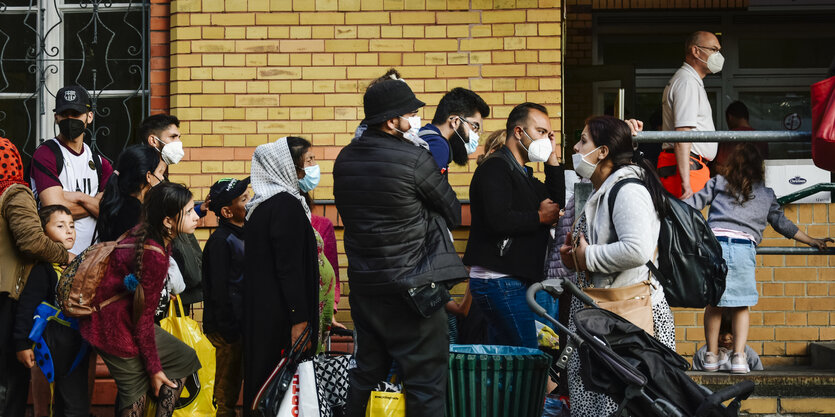 Familien mit Kindern stehen vor dem Ankunftszentrum in Wittenau Schlange.