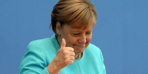 Angela Merkel vor einer blauen Pressewand.
