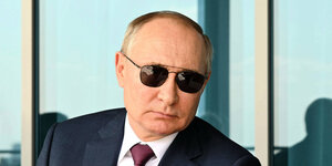 Präsident Putin vor der russischen Flagge.
