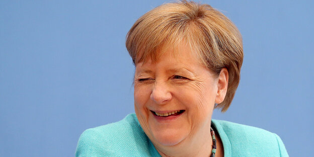 Angela Merkel kneift ein Auge zu