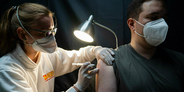 In einem Impfzelt beim Open-Air-Festival "Kulturinsel Wöhrmühle" in Erlangen verabreicht eine Mitarbeiterin des Arbeiter-Samariter-Bundes (ASB) einem Mann eine Corona-Schutzimpfung