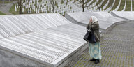 Eine Frau betet in der Gedenkstätte für die Opfer des Völkermordes von Srebrenica.