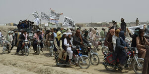 Taliban auf Motorrädern, fahnenschwingend