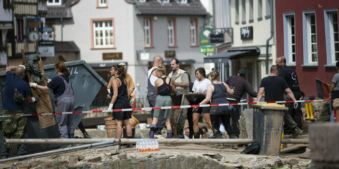 HelferInnen bilden eine Kette, um Trümmer zu beseitigen