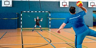 Ein Handball-Spieler wirft einen Ball auf's Tor.