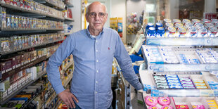 ein Mann im blauen Hemd steht in einem Kiosk