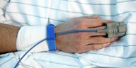 Hand eines Krankenhauspatienten , am Finger ein Gerät zur Überwachung