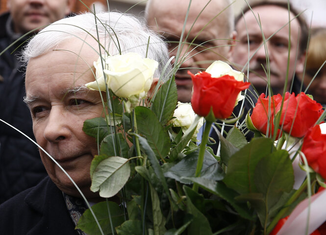 Ein Mann mit weißen Haaren hält einen Blumenstrauß