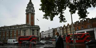 Eine Strassenszene in Lambeth. Im Hintergrund das London Council. Im Vordergrund Fußgänger und Autos.