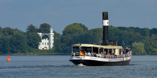 Bei strahlendem Sonnenschein zieht vor der Kulisse der Pfaueninsel auf der Havel bei Berlin der Personendampfer Gustav seine Bahn.